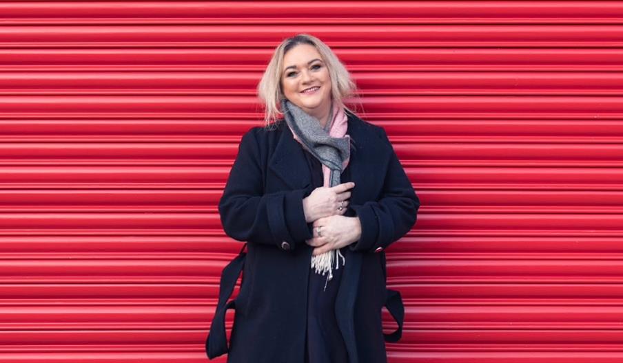 A woman standing in front of a red shutter
