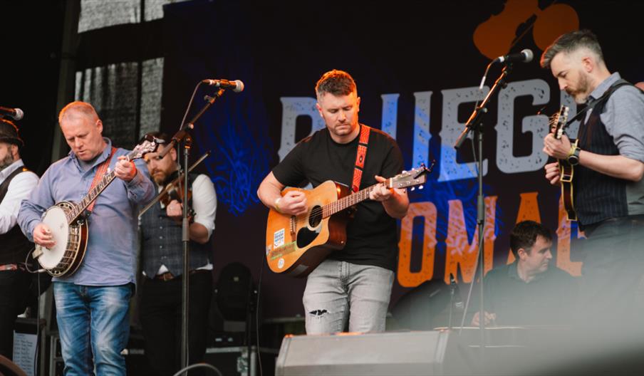 A bluegrass band of men playing on stage