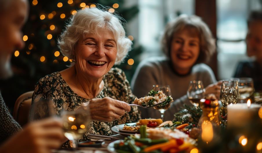 A group of elderly people enjoying a Christmas dining event