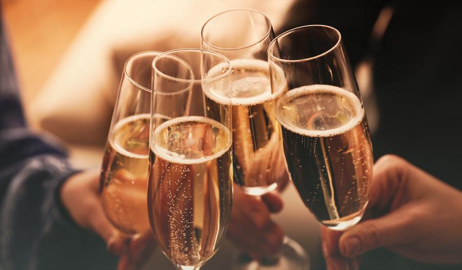 A group of four people with prosecco in glasses