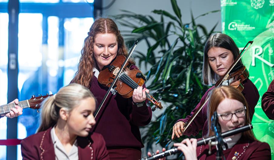 4 students playing instruments as part of a School's Traditional Music Performance