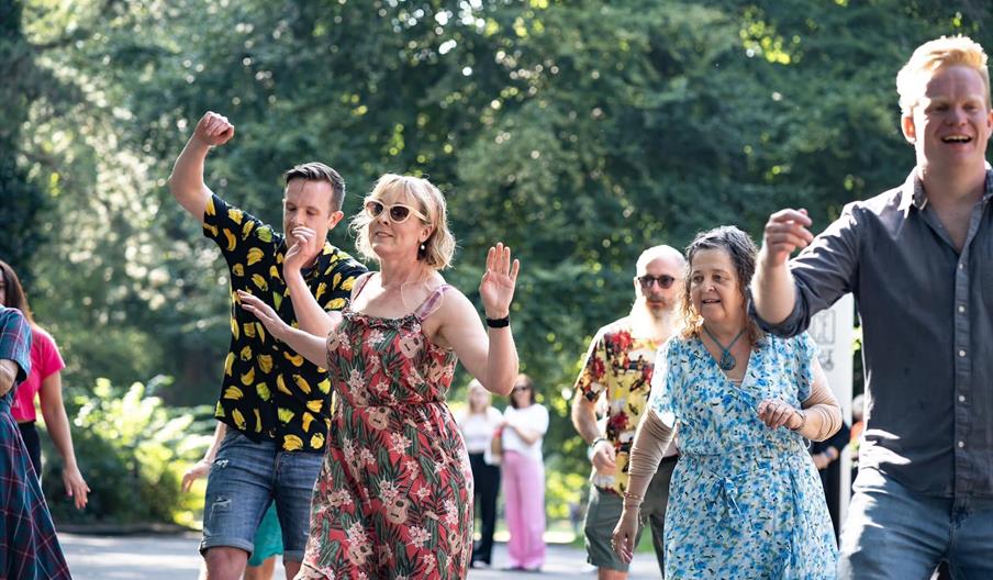 Participants enjoying an outdoor community dance class in a Ormeau Parl