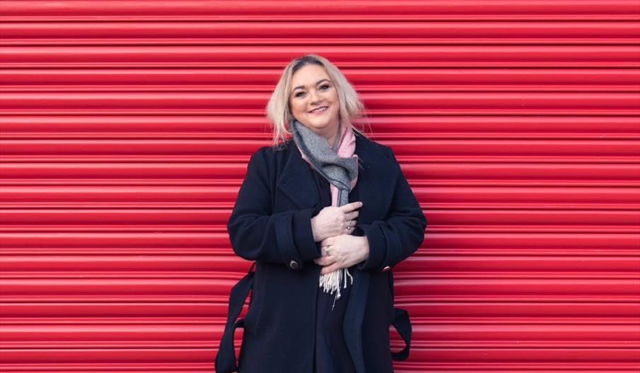 A woman standing in front of a red wall