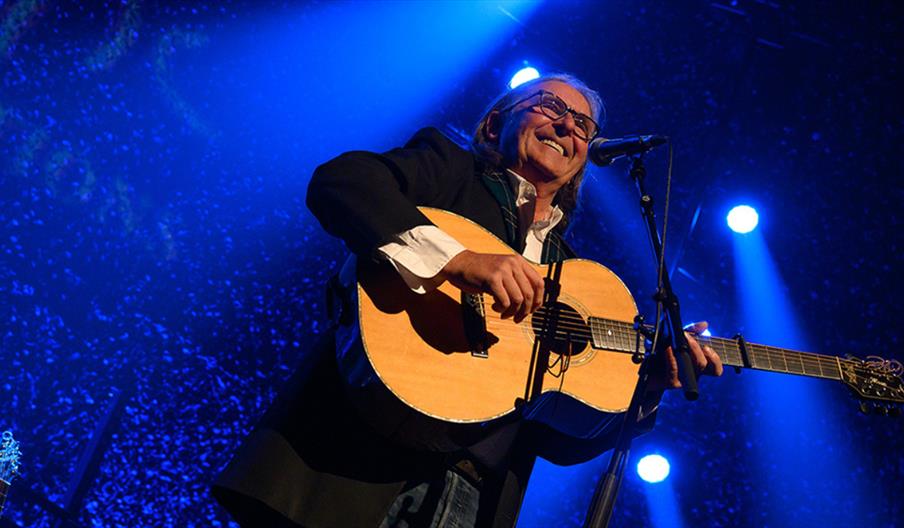 Dougie MacLean on stage playing guitar