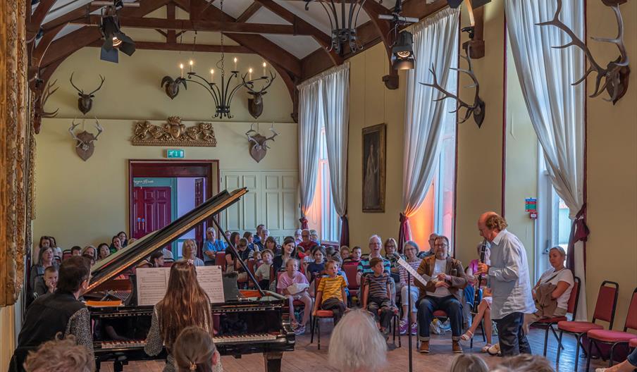 Man playing flute and lady playing piano for families
