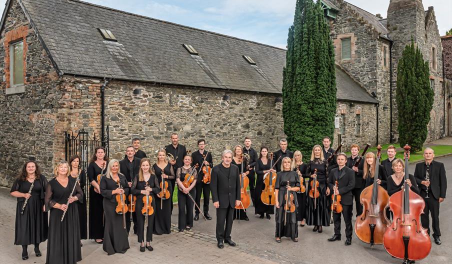 Orchestra standing in front of estate