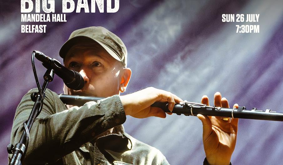 Michael playing flute with a mic stand in front of him