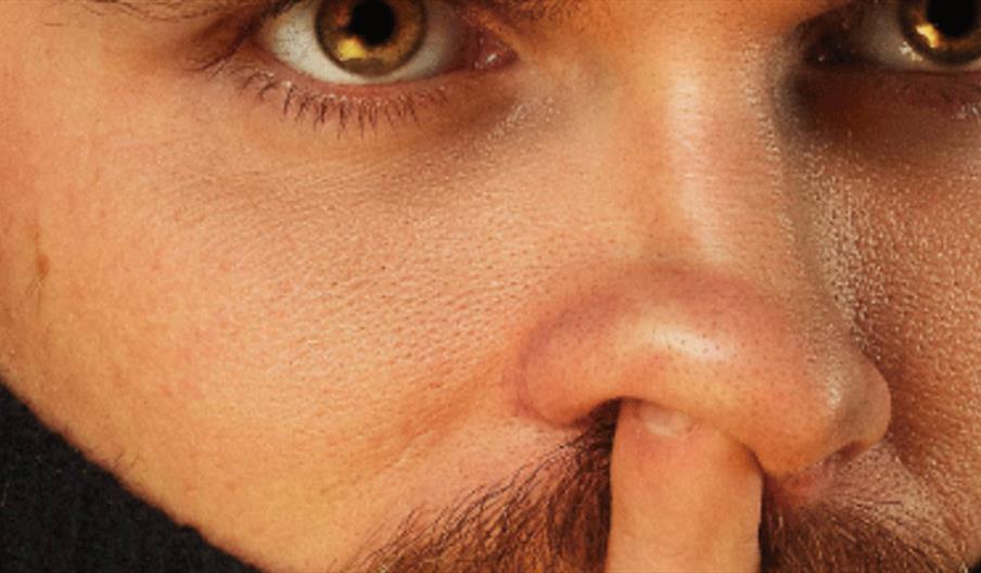 Comedian Vittorio Angelone suggestively sticking his finger up his nose.