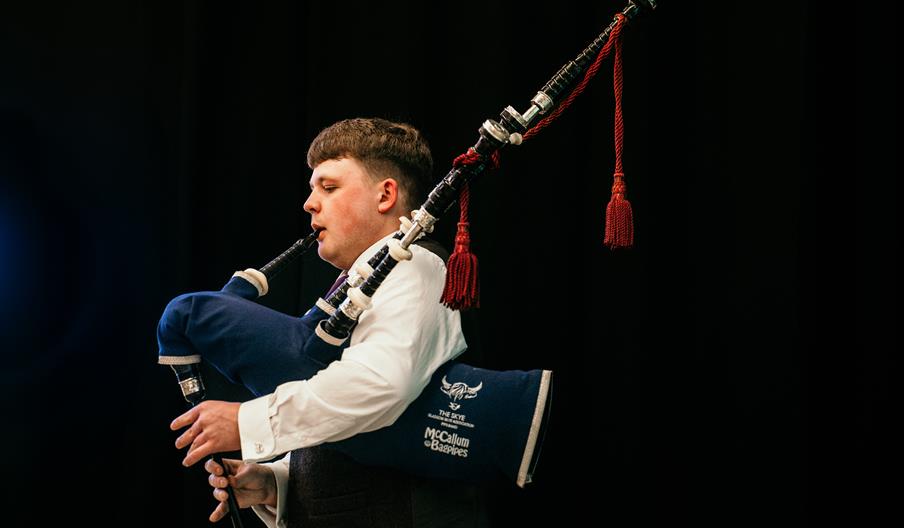 A piper plays on stage
