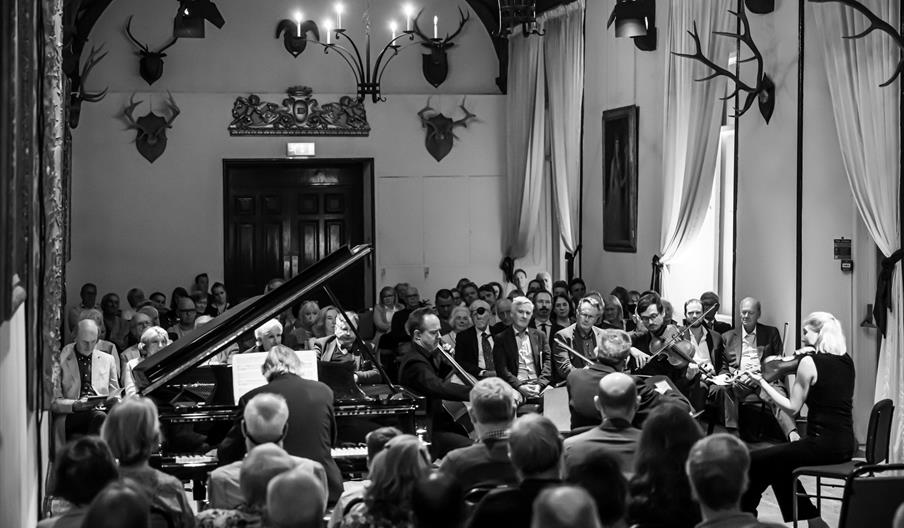 Violinist and pianist playing for crowd