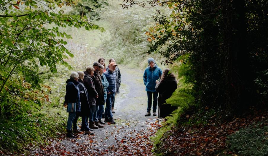 A group of people walking through a wet woodland area