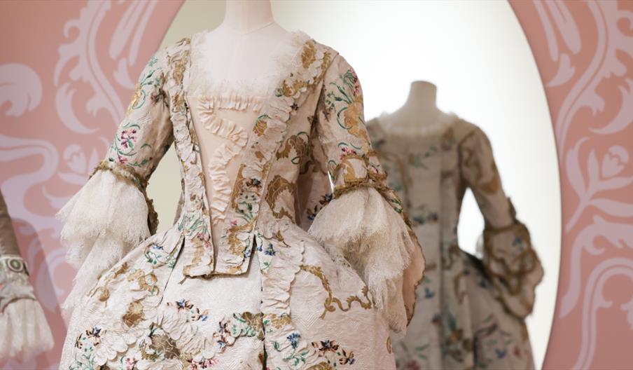 A period costume, pink and white and gold colour with white lace sleeves