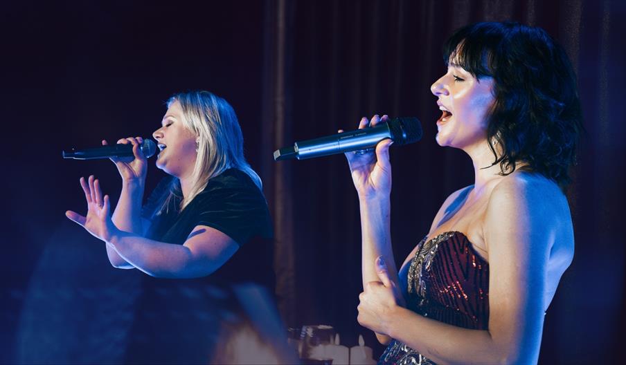 two cabaret performers on stage singing