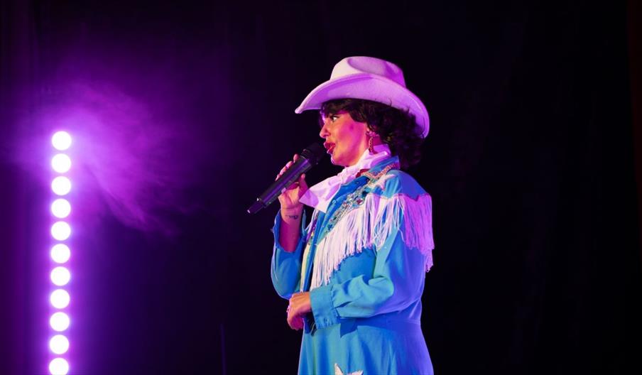 Lady in white cowboy hat on stage