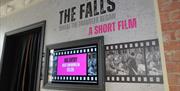 Wall display for 'The Falls: Where the Troubles Began – A Short Film' with a screen showing countdown to next viewing