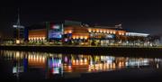 A photograph of The O2 Belfast lit at night.